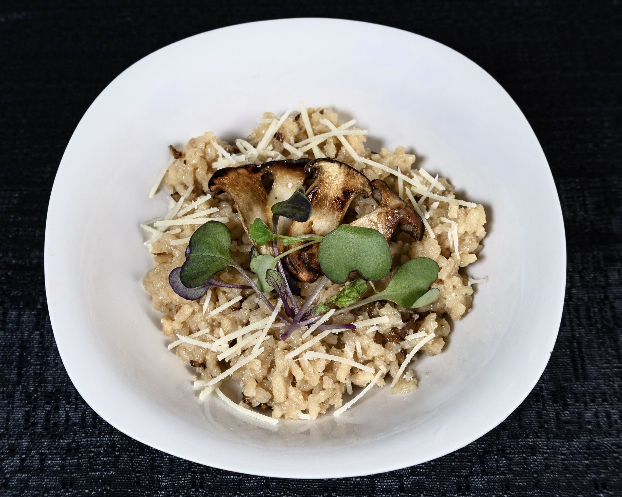 Risotto plated with mushrooms and microgreens