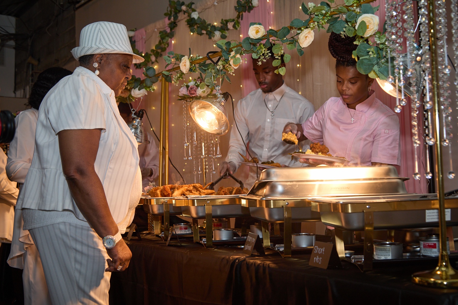 Guests being served from an elegant gold wedding buffet
